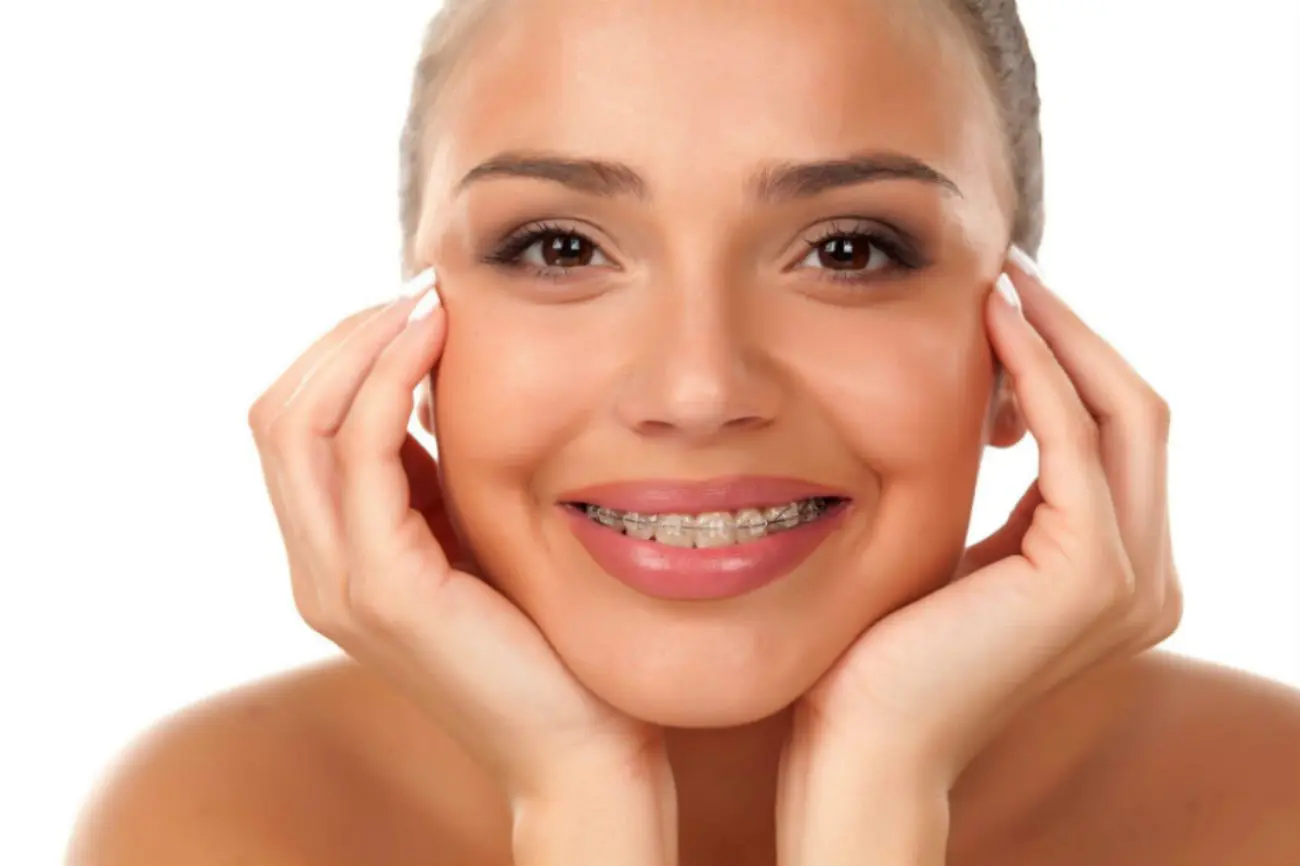 A woman with braces smiles for the camera.